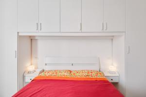 帕多瓦Corte Agordat Apartment x4 - Pet Friendly的一间卧室配有一张红色的床和白色的橱柜