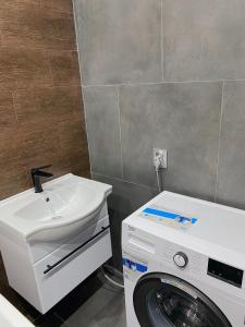 苏呼米Квартира на берегу Черного моря的一间带洗衣机和水槽的浴室
