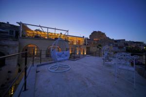 乌奇希萨尔Karlık Cave Suite Cappadocia的一个带椅子的屋顶露台和一座建筑