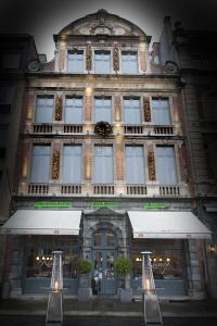 鲁汶米勒克隆酒店的一座大型砖砌建筑,前面是商店