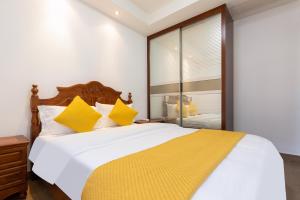 三亚三亚一克海酒店式公寓的卧室配有一张带黄色枕头的大型白色床。