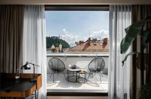 卢布尔雅那卢布尔雅那城市酒店的客房设有带桌椅的阳台。