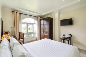 胡志明市La Bonita Hotel and Apartments的卧室设有一张白色大床和一扇窗户。