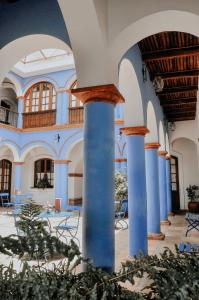 苏克雷圣玛丽亚皇家酒店的一座拥有蓝色圆柱和桌椅的建筑
