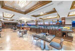 凯里尼亚Savoy Hotel Spa & Casino的一间带桌椅的餐厅和一间酒吧