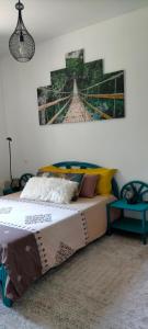 亚斯凯恩Chambre cosy entre mer et montagne的卧室配有一张床,墙上挂有绘画作品