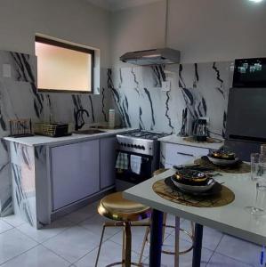 比勒陀利亚Elegant Airbnb的厨房配有炉灶和带凳子的桌子。