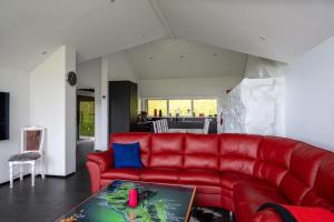SkálavíkLuxurious cabin / 3 BR / Scenic village的客厅里一张红色的沙发,配有桌子