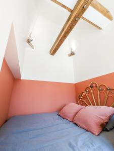 DoschesLa Maison T&M的橙色和白色墙壁间的一张床位