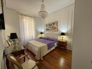 罗马国王广场住宿加早餐旅馆的一间卧室配有一张床、两把椅子和一个吊灯