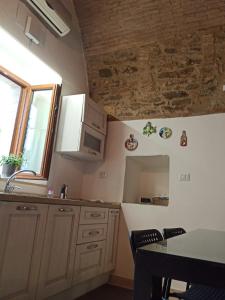PomaricoMatalena的厨房配有白色橱柜、桌子和窗户。
