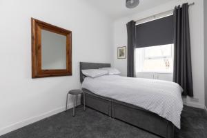 珀斯Lovely City Centre 1 bedroom flat.的一间卧室配有一张带镜子的床和窗户