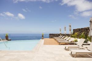 Las IndiasAnamcara Suites的一个带椅子的游泳池,享有海景