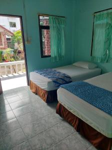 哈林海滩Charung Bungalows的蓝色墙壁客房的两张床