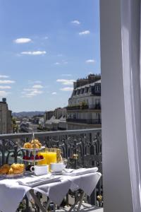 巴黎Manolita Paris的阳台上的桌子上摆放着食物和饮料