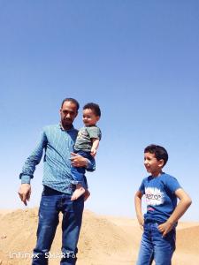 赫尔格达رحله تسوق الغردقه的站在沙子里抱着孩子的男人