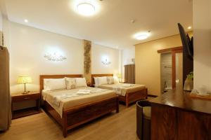 科隆Jai-cob’s Suites的酒店客房配有两张床和一张书桌