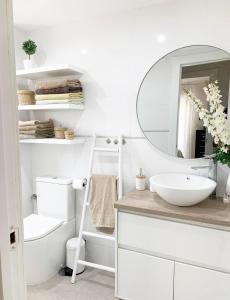 阿尔姆尼卡APARTAMENTO EN LA PLAYA CON VISTAS DE ENSUEÑO的白色的浴室设有水槽和镜子