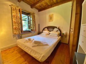 奥尔迪诺Pleta de Ordino 55 Casa Rústica hasta 6 personas的一间小卧室,配有一张带窗户的床