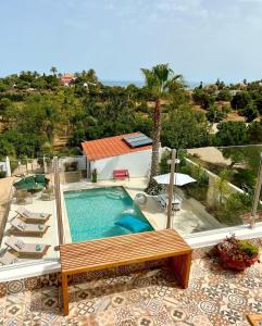 卢斯Palm View Guesthouse, adults only的一个带长凳和房子的游泳池
