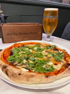 基里缪尔Airlie Arms Hotel的桌上的比萨饼和一杯啤酒