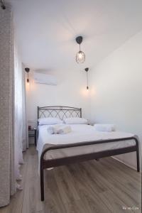 阿特米达Oresti's Villa Near Airport & Beach的白色卧室配有带白色床单和枕头的床