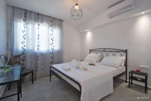 阿特米达Oresti's Villa Near Airport & Beach的一间卧室配有带白色床单和枕头的床。