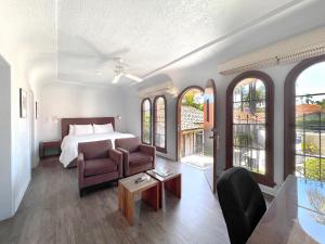 圣巴巴拉卡萨德尔玛酒店的一间卧室配有一张床、一张沙发和一把椅子