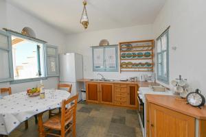 圣约阿尼斯Astraia的厨房配有桌子、冰箱和桌椅