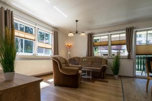 施尔奇Ferienanlage Zum Wildbach Schierke的客厅配有两把椅子和一张桌子,窗户