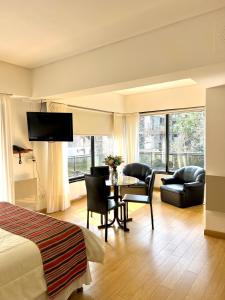 布宜诺斯艾利斯高尔夫大厦套房&公寓酒店的酒店客房带一张床、一张桌子和椅子