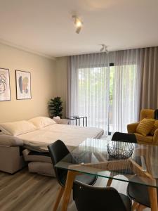 丰沙尔Dona I Apartments at Botanical Garden的客厅配有床和玻璃桌