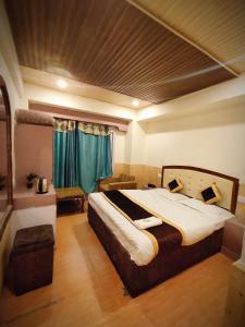 西姆拉Shorya Regency的一间卧室配有一张带绿色窗帘的大床
