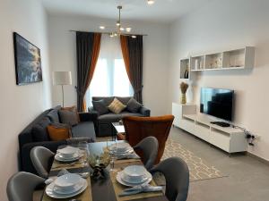 迪拜Birchfort - Newly renovated unique 1 bedroom apartment的客厅配有桌子和沙发
