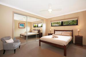 BewongPanorama at Jervis Bay I Pet Friendly I 15 Mins to Hyams Beach的一间卧室配有一张床、一把椅子和镜子