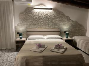 布林迪西Villa Anna GuestHouse的一间卧室配有两张带毛巾的床