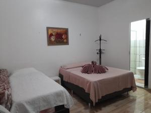 索雷Pousada Solar Encanto do Marajó的卧室配有两张床,墙上有一个十字架