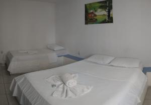 若昂佩索阿Pousada Nascer do Sol的一间卧室配有两张带毛巾的床
