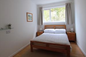 查尔斯敦Porthpean Apartment的一间卧室设有一张床和一个窗口