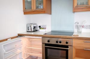 查尔斯敦Porthpean Apartment的厨房配有炉灶和开放式冰箱。