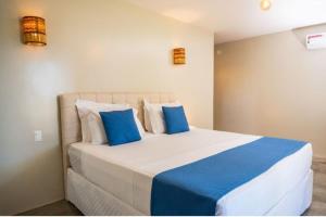 卡莫辛Villa Zen Hotel的一间卧室配有一张带蓝色和白色枕头的床