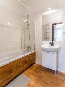华沙FIRST -- Green Żoliborz apartment 3的浴室配有水槽、淋浴和浴缸。
