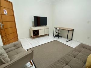 马里利亚Área Central/3 quartos/grande grupos的带沙发、书桌和电视的客厅