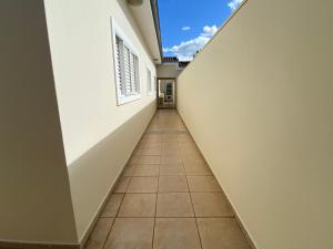 马里利亚Área Central/3 quartos/grande grupos的一条铺着瓷砖地板的空建筑走廊