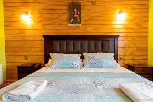 纳塔列斯港露西住宿加早餐旅馆的卧室配有木墙内的一张床