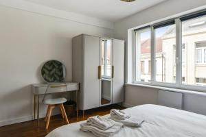 里尔Beautiful apartment near the Wazemmes market - Lille - Welkeys的一间卧室配有一张床、一张桌子和一面镜子