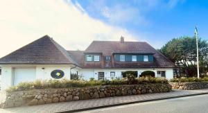 韦斯特兰Meer-Lust-Sylt sea cottage的一座白色的大房子,设有石墙