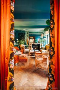 安特卫普Flora的客厅配有橙色窗帘和壁炉