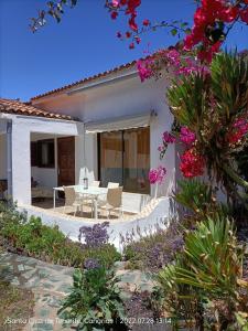 拉克鲁斯Schöne Wohnung in Puerto de la Cruz mit Garten.的白色的房子,配有桌子、椅子和鲜花