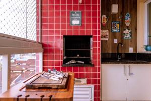 伯迪亚哥VARANDA GOURMET c churrasqueira-3 quartos- Wi-fi的厨房设有红色瓷砖墙壁和烤箱